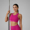 Femme tenant une barre de Pole Dance et portant une brassière de Pole Dance rose