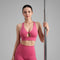 Femme tenant une barre de Pole Dance et portant une brassière de Pole Dance rose