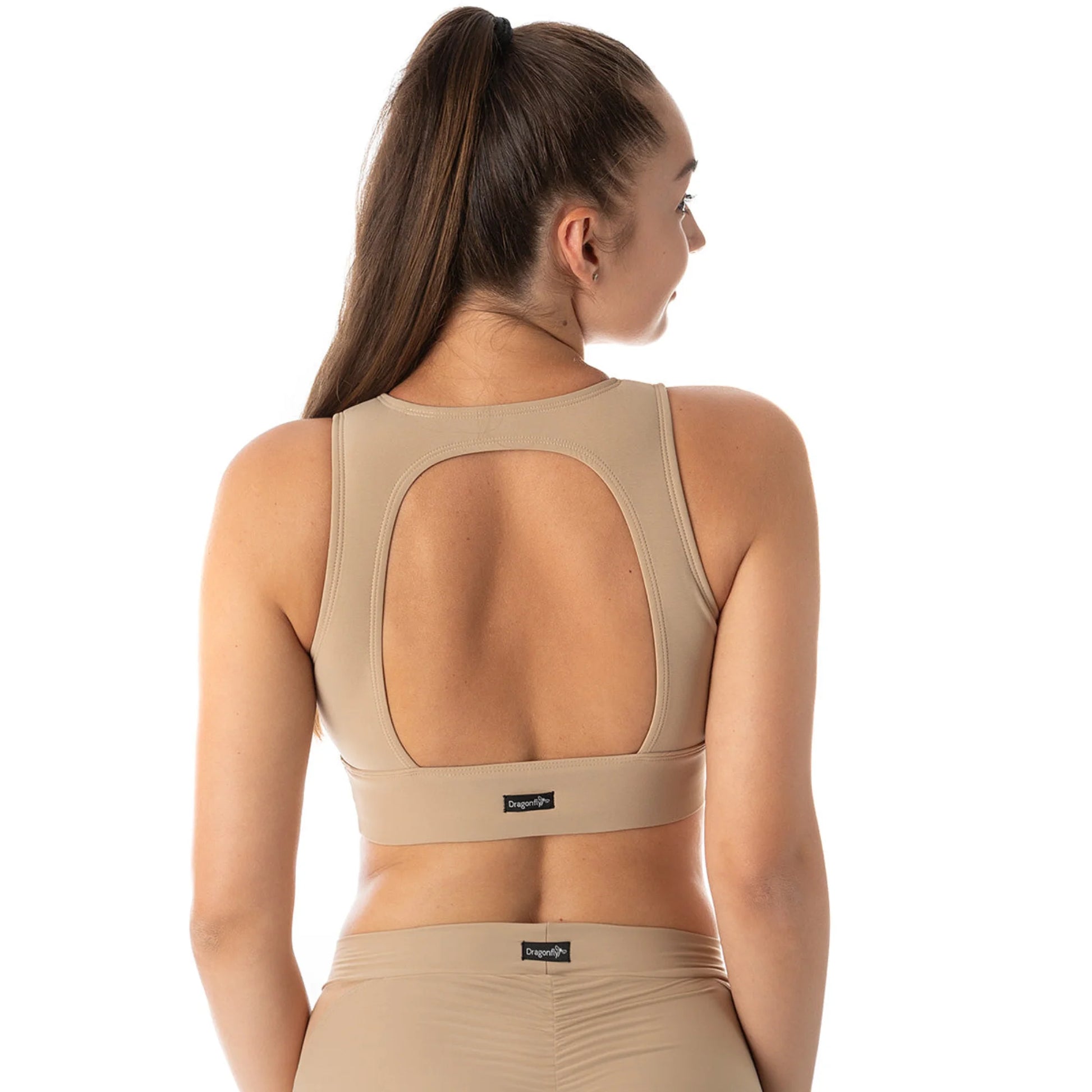 Femme de dos portant une brassière couleur beige pour la pole dance de marque dragonfly