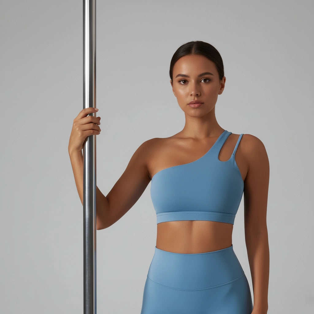 Femme tenant une barre de Pole Dance et portant une brassière de Pole Dance bleue claire