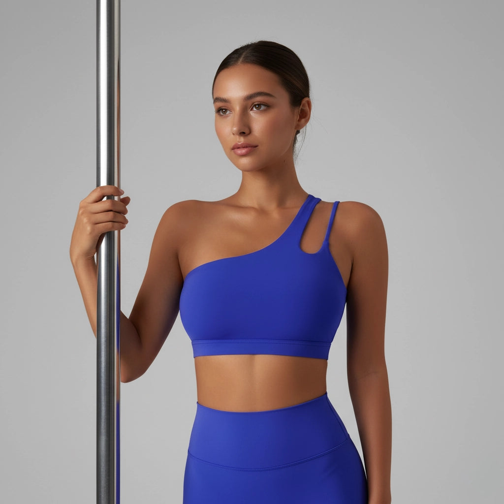 Femme tenant une barre de Pole Dance et portant une brassière de Pole Dance bleue foncée