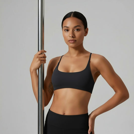 Femme tenant une barre de pole dance et portant une brassière de Pole Dance noire