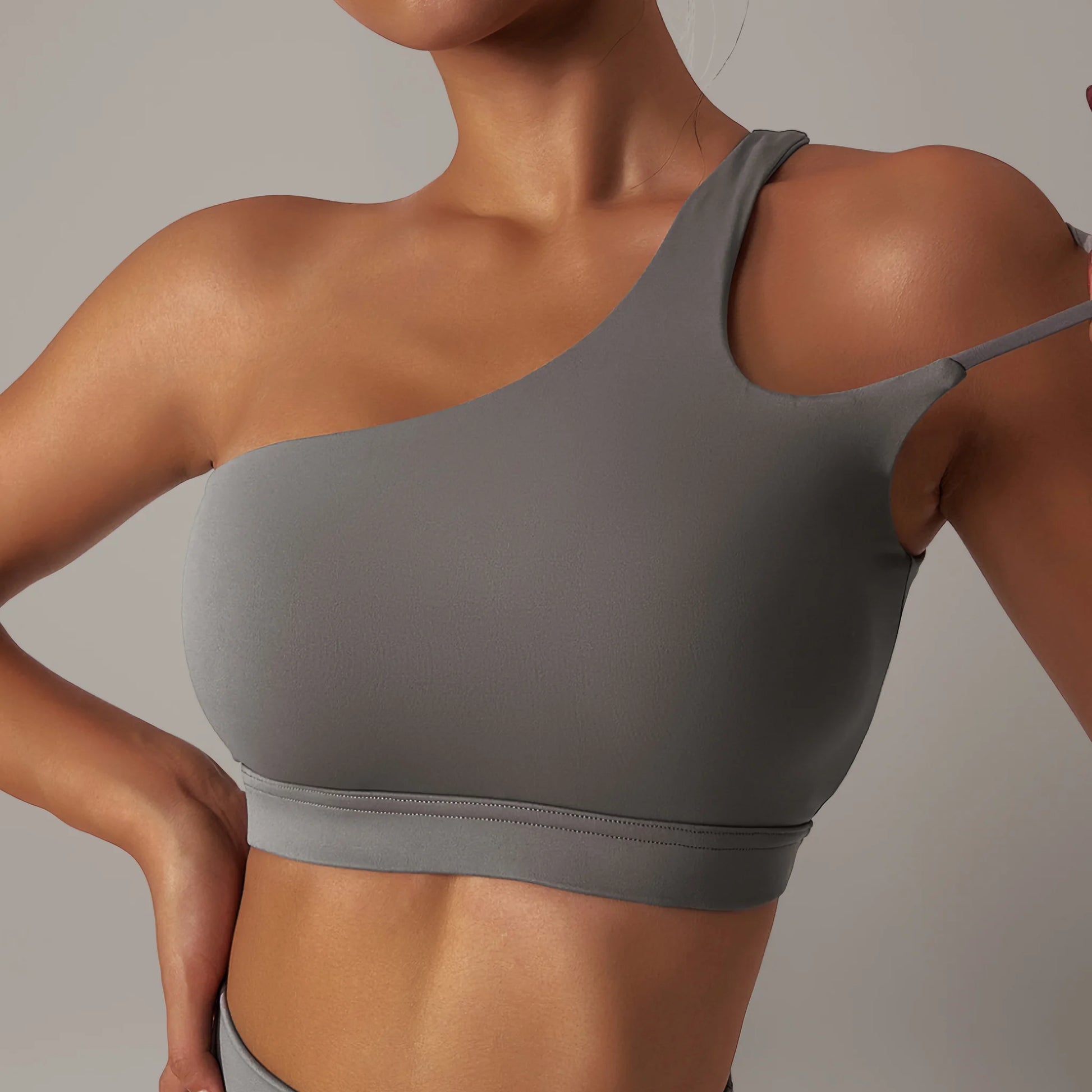 Femme portant une brassière de pole dance à design asymétrique grise