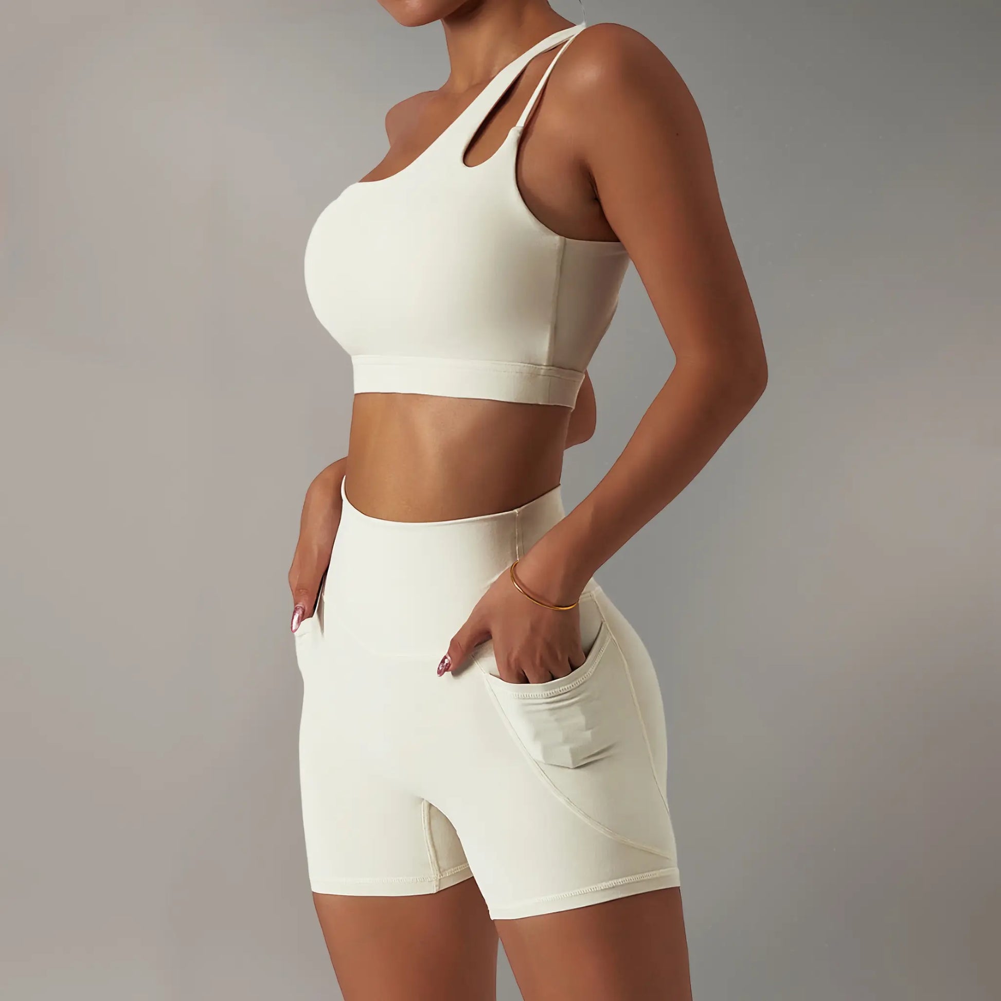 Femme portant une brassière de pole dance à design asymétrique ivoire