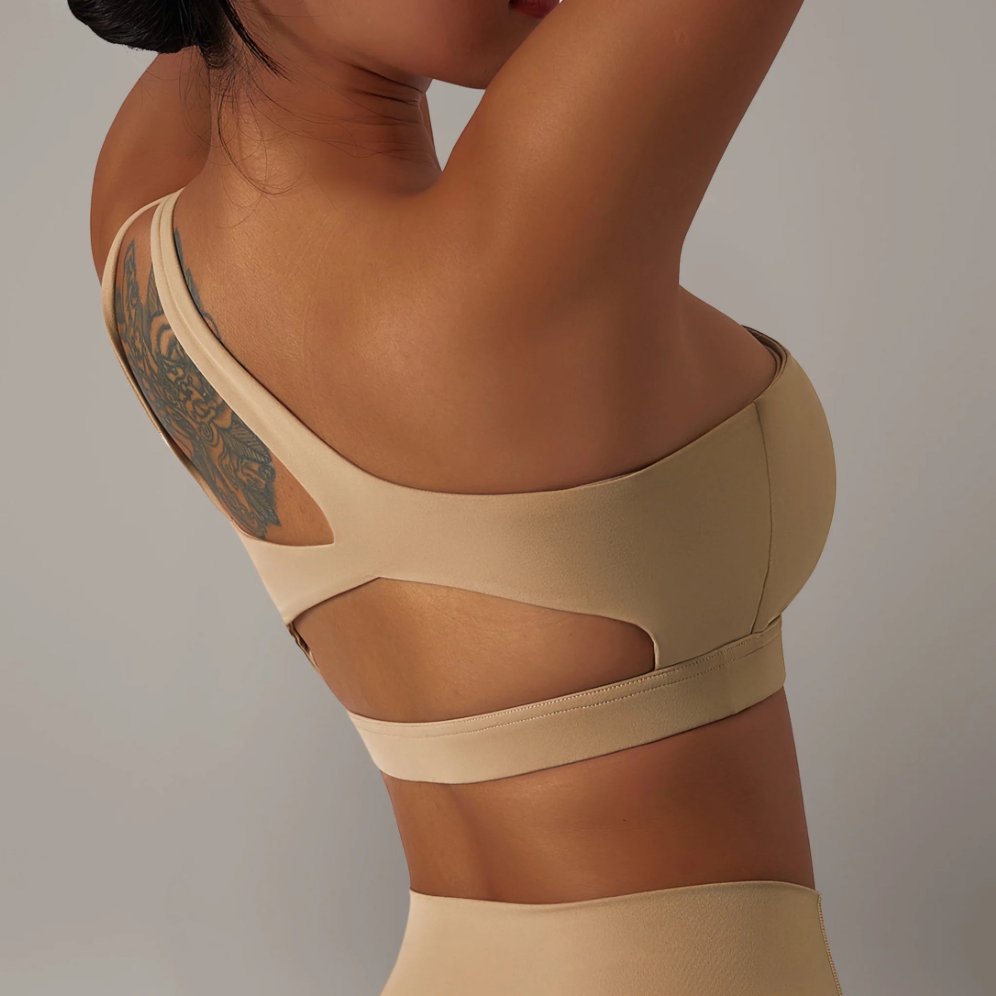 Femme portant une brassière de pole dance à design asymétrique marron naturel
