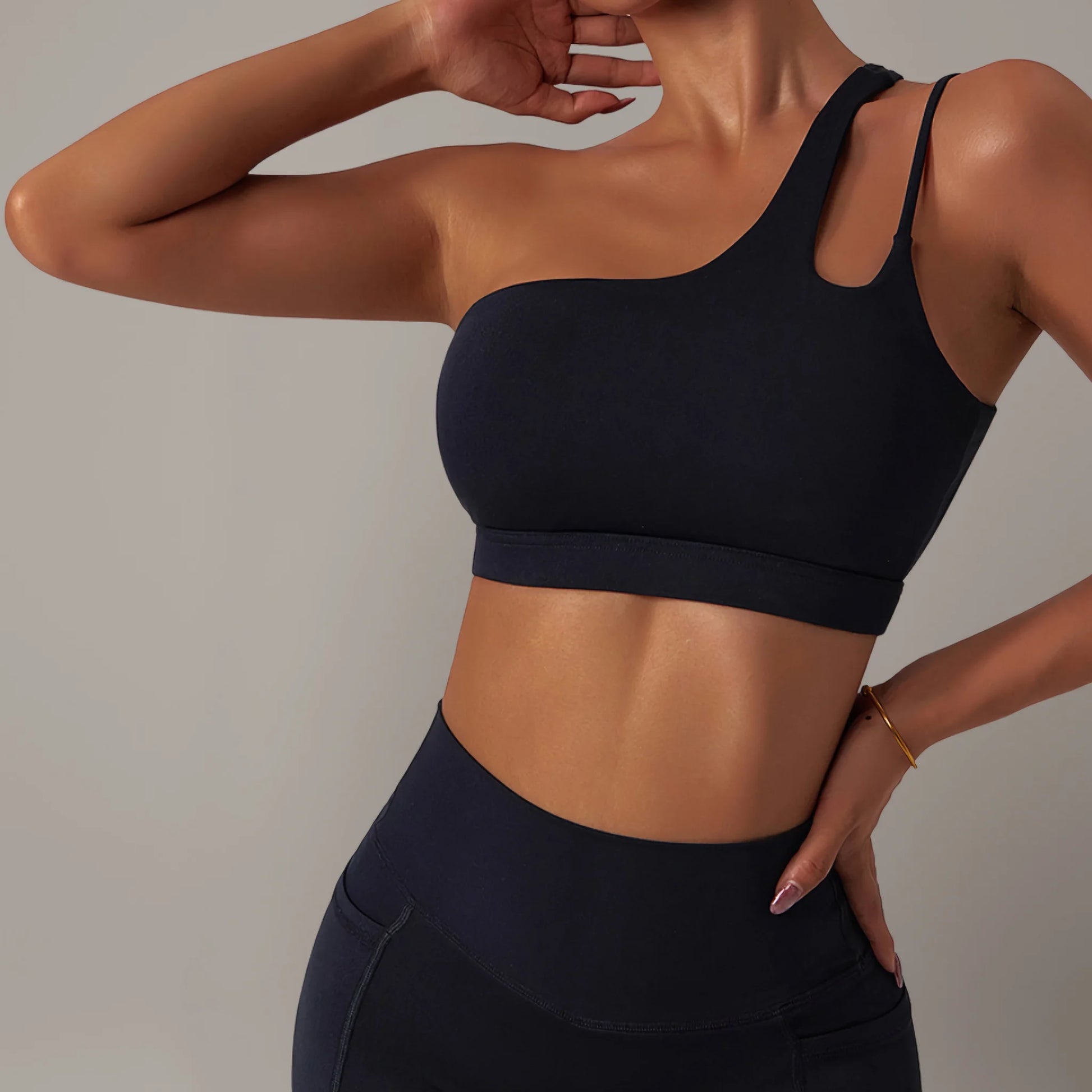 Femme portant une brassière de pole dance à design asymétrique noir