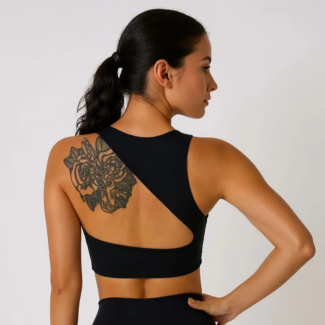 Femme portant une brassière de pole dance noir à design asymétrique