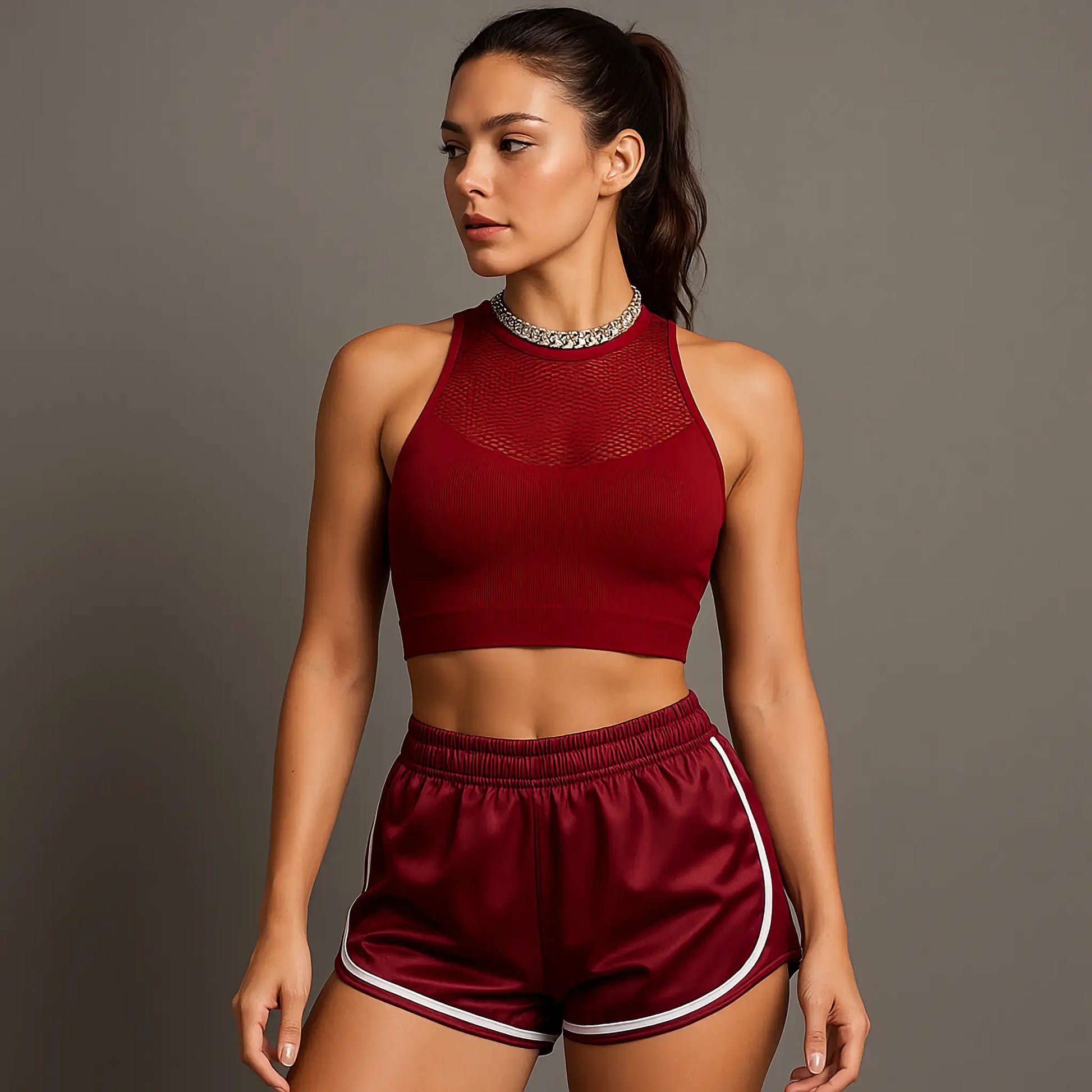 Femme portant une brassière de Pole Dance rouge ainsi qu'un short satinée de Pole Dance rouge