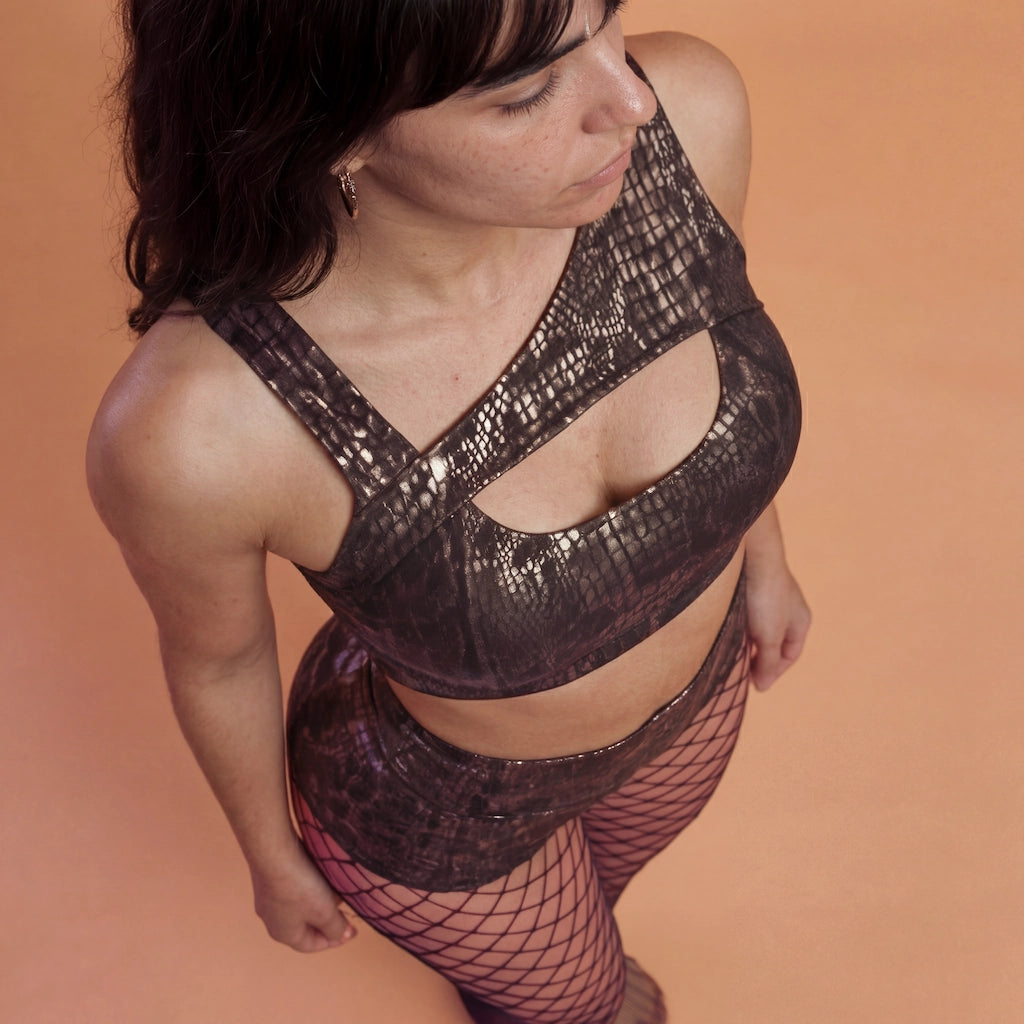 Mannequin portant l’ensemble Gloss Fit Tabac Doré de Pole Dance Chic, tenue de pole dance avec haut asymétrique et short taille haute.