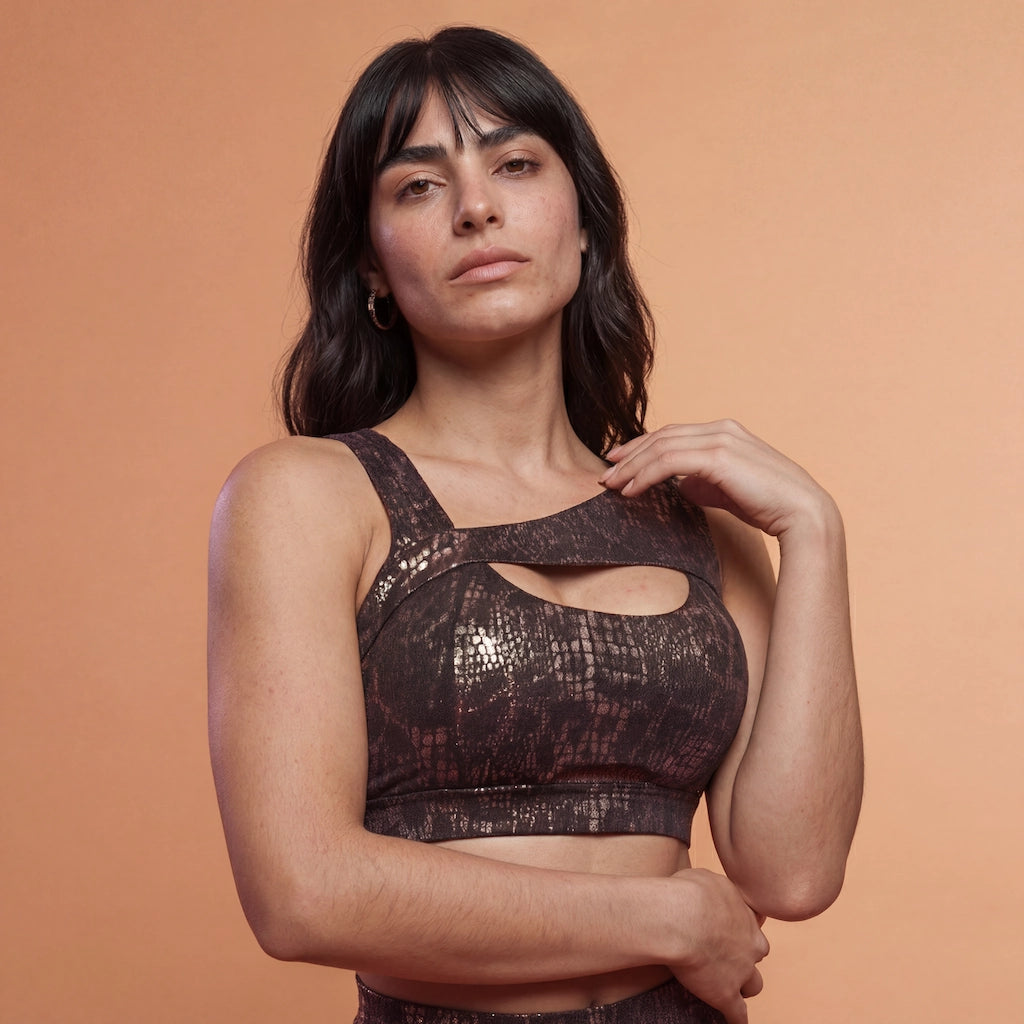 Mannequin portant l’ensemble Gloss Fit Tabac Doré de Pole Dance Chic, tenue de pole dance avec haut asymétrique et short taille haute.