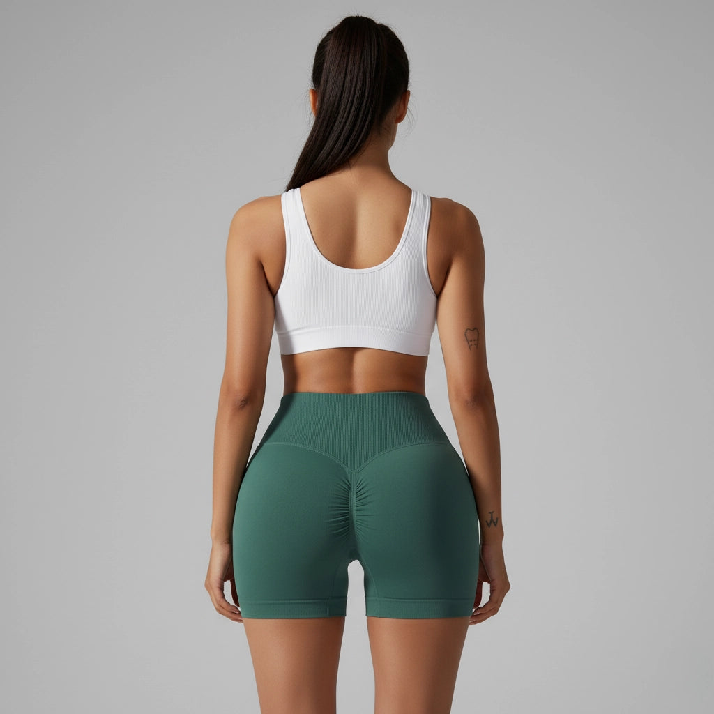Vue de derrière d'une femme tenant une barre de pole dance et portant un short de pole dance à taille haute évasée vert