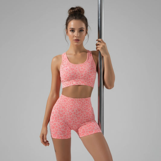 Femme tenant une barre de pole dance et portant un short de pole dance aux motifs léopard rose